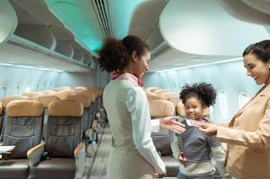 Flight attendant greet passengers as they enter the aircraft to locate a seat in the cabin. photo