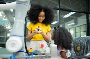 niños utilizando el mano robot tecnología, estudiantes son estudiando tecnología, cuales es uno de el vástago cursos foto