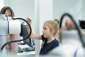 niños utilizando el mano robot tecnología, estudiantes son estudiando tecnología, cuales es uno de el vástago cursos foto