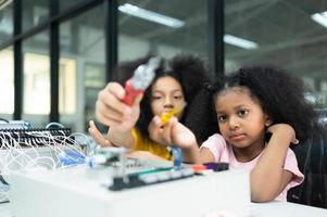 Children using the hand robot technology and having fun Learning the electronic circuit board of hand robot technology, which is one of the STEM courses. photo