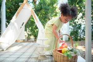 un brillante y linda pequeño niña con divertido jugando en el jardín de el casa. foto