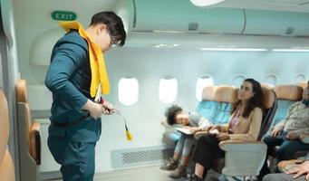 Flight attendants show how to use safety devices and recommend emergency exits. photo