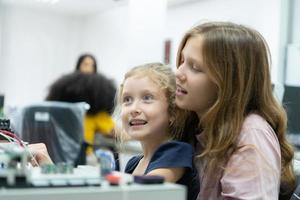 Children using the hand robot technology and having fun Learning the electronic circuit board of hand robot technology, which is one of the STEM courses. photo