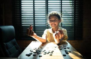 retrato de un pequeño niña en oficina habitación de casa con un juego de Vamos siendo aprendió a construir concentración y inteligencia. foto