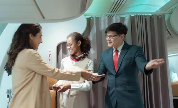 Flight attendant greet passengers as they enter the aircraft to locate a seat in the cabin. photo