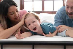 After the little boy wakes up from his nap, his father and mother engage in enjoyable activities in his bedroom. photo