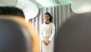 Flight attendants show how to use safety devices and recommend emergency exits. photo