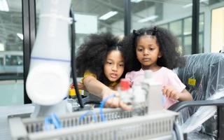 niños utilizando el mano robot tecnología, estudiantes son estudiando tecnología, cuales es uno de el vástago cursos foto