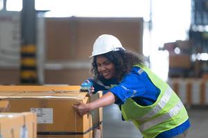 Worker in auto parts warehouse Packing small parts in boxes after inspecting the car parts that are ready to be sent to the car assembly plant. photo