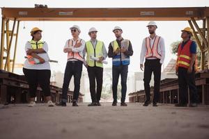 Group of architects, construction foremen, and construction engineers review the work and talk about how the project, in the construction site. photo