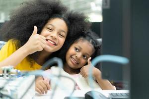 Children using the hand robot technology and having fun Learning the electronic circuit board of hand robot technology, which is one of the STEM courses. photo