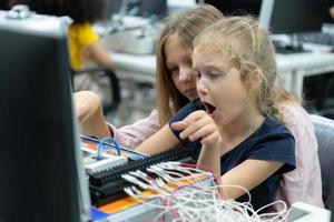 Children using the hand robot technology and having fun Learning the electronic circuit board of hand robot technology, which is one of the STEM courses. photo