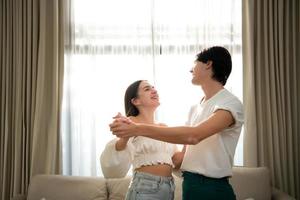 Young couple in the living room of the house in the morning, Dancing happily together photo