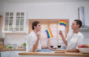 LGBT Young couple celebrate the day of love between each other with fine wine in the kitchen of the house photo