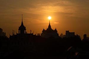 At a temple in the central of Bangkok Thailand, The morning sun will gradually move up to stand out at the end of this temple pagoda. This miracle happens only twice a year. photo