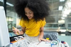 Youngsters utilizing the hand robot technology are having fun learning the electronic circuit board of hand robot technology, which is one of the STEM courses. photo