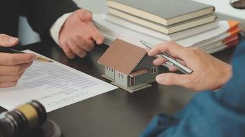 Business and lawyers discussing contract papers with brass scale on desk in office. Law, legal services, advice, justice and law concept picture with film grain effect video