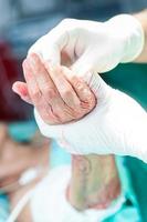 doctor disinfecting the hand of a patient prior to a hand surgery photo