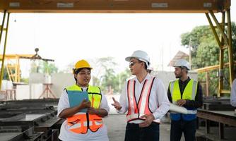 Group of architects, construction foremen, and construction engineers review the work and talk about how the project, in the construction site. photo