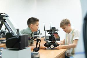 niños utilizando el mano robot tecnología, estudiantes son estudiando tecnología, cuales es uno de el vástago cursos foto