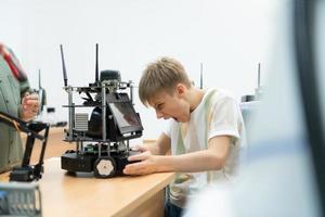 niños utilizando el mano robot tecnología, estudiantes son estudiando tecnología, cuales es uno de el vástago cursos foto