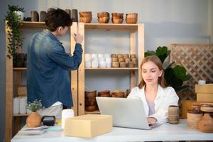 A young couple runs a small business making clay jewelry. They support one another as they work toward becoming larger business in the future. photo