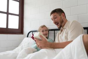 Father and daughter in the evening bedroom, with a surprise from a daughter who had prepared a birthday present. photo