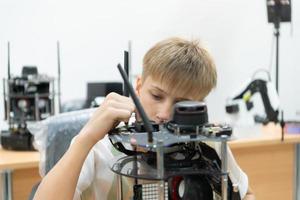 niños utilizando el mano robot tecnología, estudiantes son estudiando tecnología, cuales es uno de el vástago cursos foto