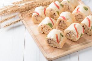 tuna in roll soft bread on white wood background photo