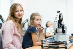 Children using the hand robot technology and having fun Learning the electronic circuit board of hand robot technology, which is one of the STEM courses. photo