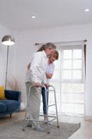 Old couple with her husband, who had to learn to walk after being treated for an osteoarthritis. Must help and take care of each other without children to take care of. photo