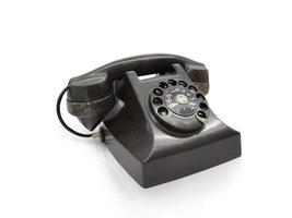 Old fashioned desk phone, side view isolated against white background photo