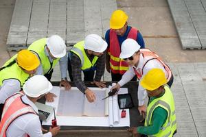 Construction engineers, architects, and foremen form a group. Participate in a meeting to plan new construction projects. photo