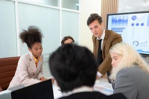 In the meeting room of an international business corporation, a diverse group of young entrepreneurs are enthusiastically taking their ideas and sharing perspectives. photo