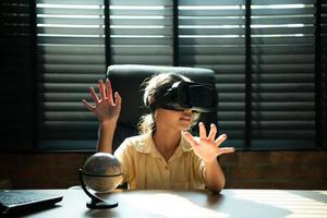 Portrait of little girl in office room of house with gestures that are expressed when playing virtual reality games photo