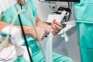 Anesthesiologist doctor getting ready to give anesthesia to the patient in the surgery room photo