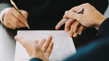 Justice and Law concept. Legal counsel presents to the client a signed contract with gavel and legal law or legal having team meeting at law firm in background video