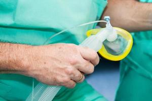 Anesthesiologist doctor holding an anesthesia mask in the surgery room photo