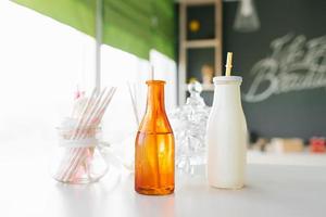 Glass multicolored bottles with tubes on the bar at the party photo