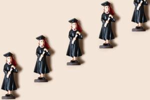 Class of 2023 concept. Wooden number 2023 with graduate statuette on color background photo