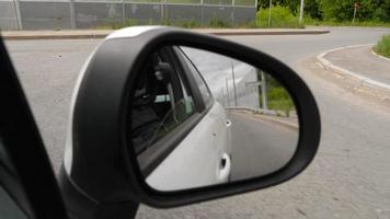 de viaje en el carretera, ver desde el vista trasera espejo. carros siguiendo y campo video