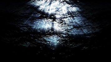 Las olas submarinas del océano ondulan y fluyen con rayos de luz - bucle video