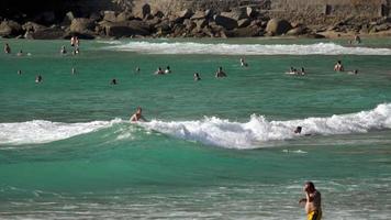 PHUKET, THAILAND NOVEMBER 22, 2018 - Slow motion long shot, many people are swimming in the azure ocean. Big waves crash on the shore video