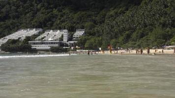 gehen entlang das Meer Küste von Phuket Insel. Konzept von Paradies Ferien und exotisch Reise. Wellen rollen auf das Strand. Menschen schwimmen Weg von das Ufer video