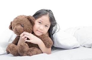 Happy asian cute girl hugging teddy bear photo