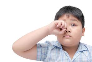 Obese boy itchy his eyes because dust in eye photo
