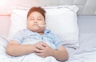 Sick obesity boy sleep with thermometer photo