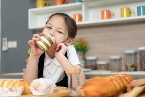 Portrait of a little girl in the kitchen of a house having fun playing baking bread photo