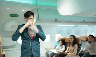 Flight attendants show how to use safety devices and recommend emergency exits. photo