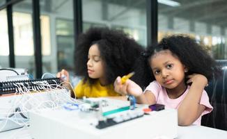 Children using the hand robot technology and having fun Learning the electronic circuit board of hand robot technology, which is one of the STEM courses. photo